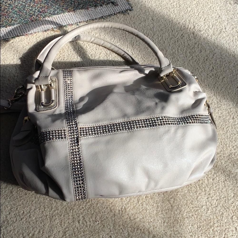 Oversized tan purse with rhinestone cross